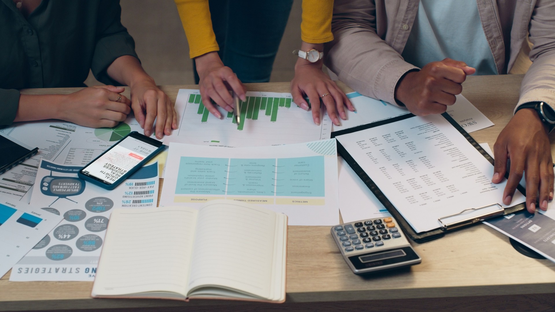 Business people, hands and meeting with documents for marketing strategy or data at night on office desk. Top view of market team working late on paperwork or planning with graph, chart or statistics